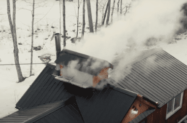 Smoke pours out of a maple making house during the maple making process in this aerial photo.
