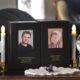 An end-table memorial for William McIver and Kelly McIver featuring a candle for each and photos of each.