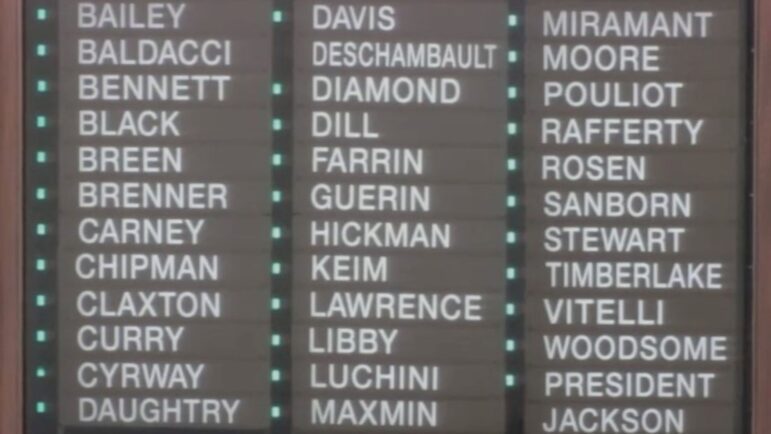 Many of the lights near state senators names on a roll call board in the Maine State Senate are lit green for affirmative votes.