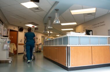 A nurse walks past a desk within the interior of a nursing home