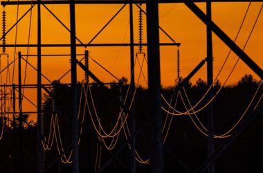 transmission lines against an orange sky