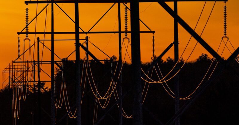 transmission lines against an orange sky