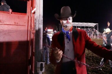 A rodeo clown exists the performance area.