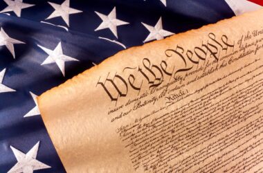 A stock image of the U.S. flag and the Declaration of Independence