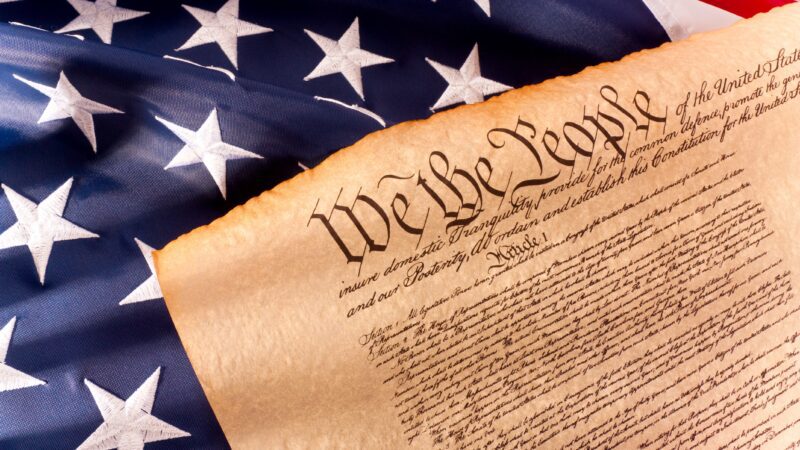 A stock image of the U.S. flag and the Declaration of Independence
