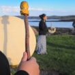 A group of three women beat hand-held drums as part of a Passamaquoddy cultural event