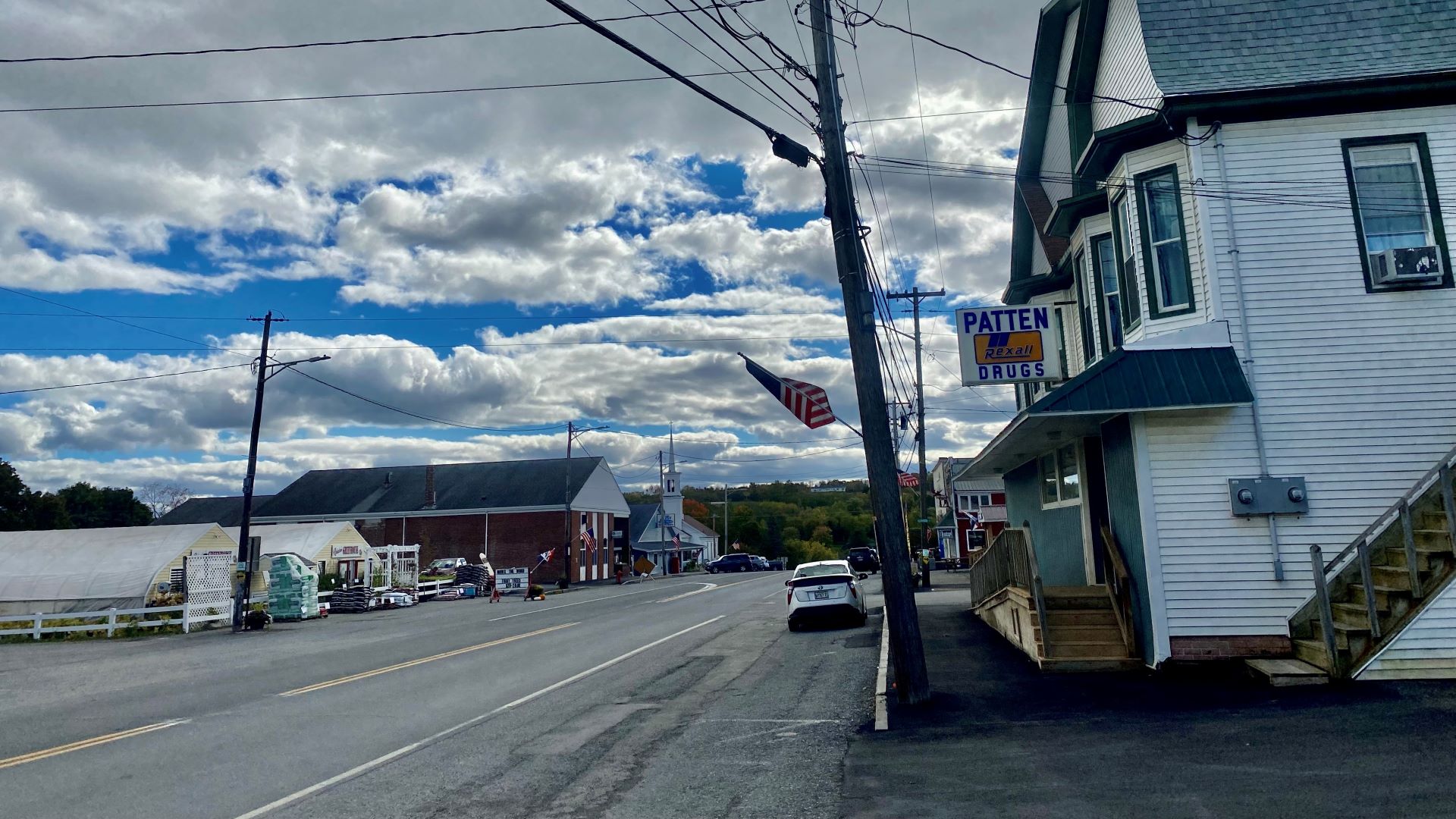 A view of a street lined on both sides with businesses in Patten, Maine
