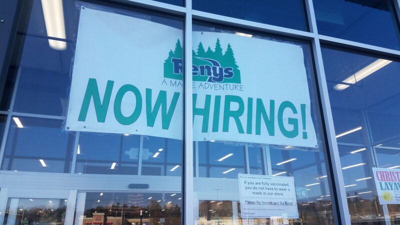 A now hiring banner hands in the entrance of a Renys location