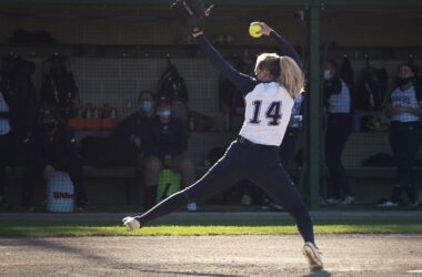 A pitcher for the University of Southern Maine softball team in the middle of her windup during a game