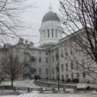 Exterior of the Maine State House in December 2021 with some remnants of snow on the ground.