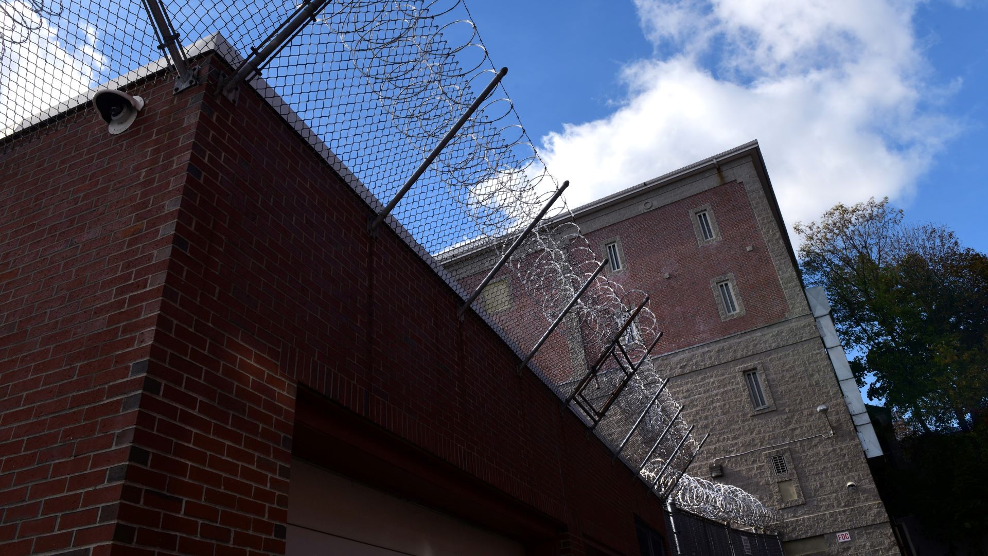 Exterior of the Androscoggin County Jail, including barbed wire at the top of a wall