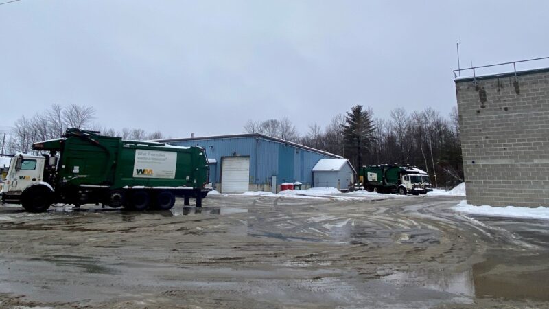 A WasteManagement truck drives through the parking lot of a waste facility