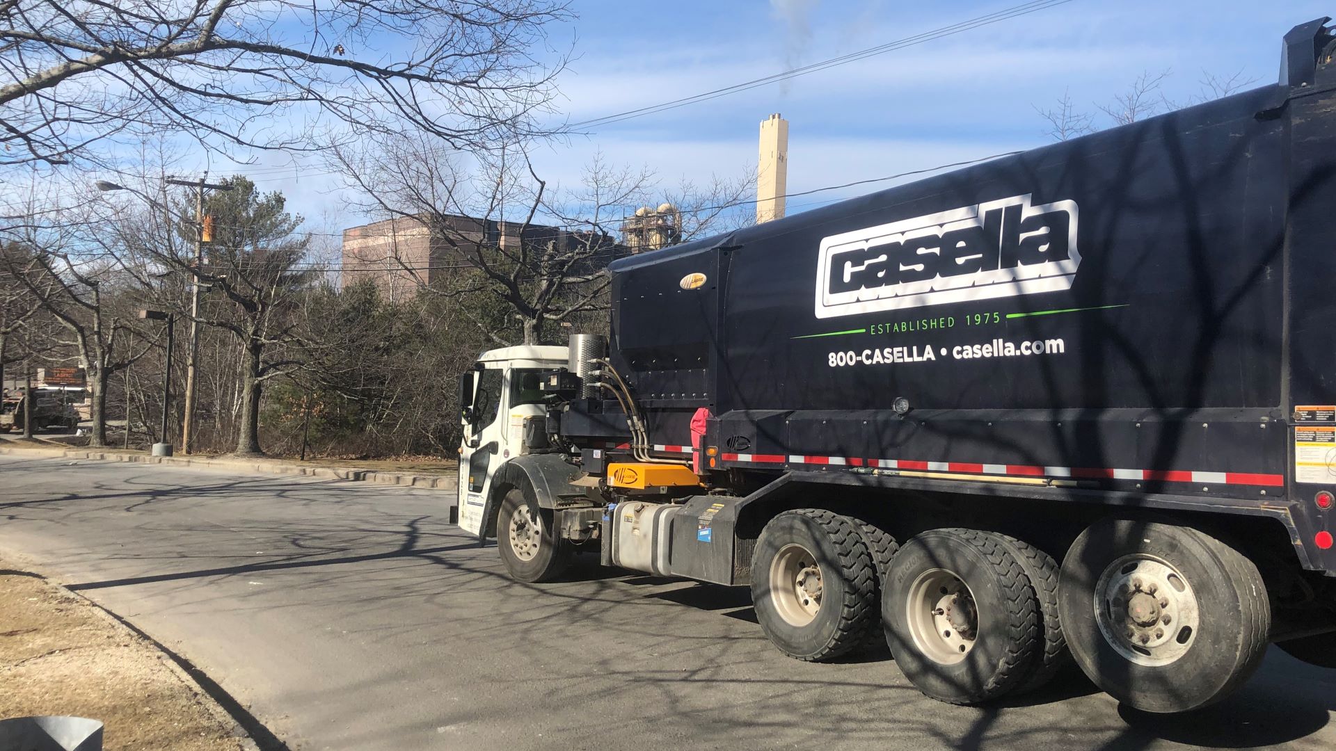 A dark blue Casella garbage truck parked on a street