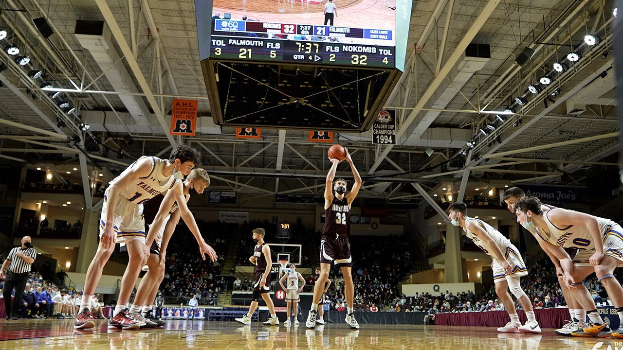 A basketball player prepares to release the ball while shooting a free throw