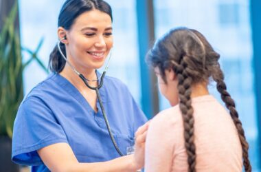 A nurse uses a stethoscope on a young Native American girl