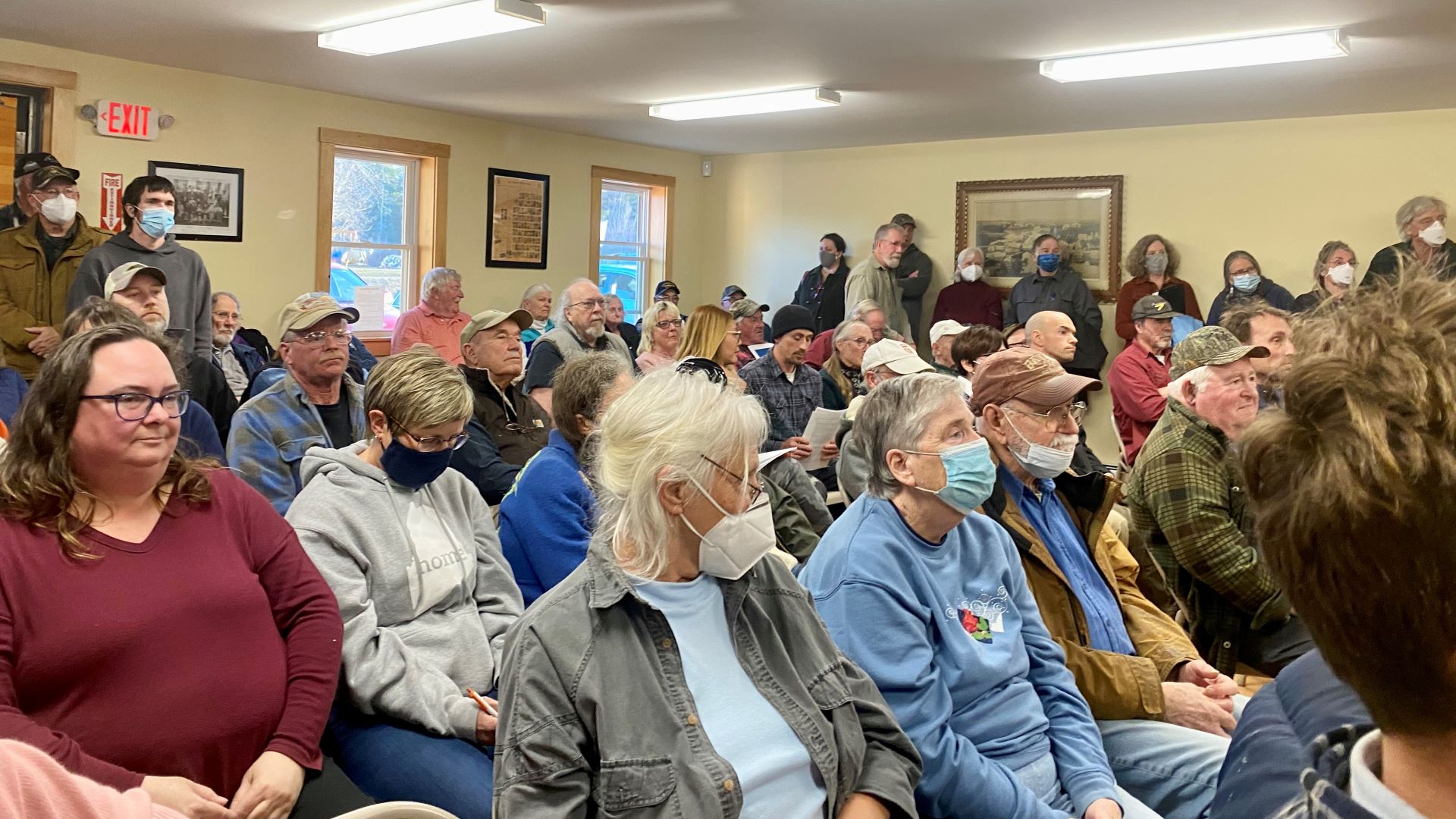 A group of residents listen to company representatives at a town hall event