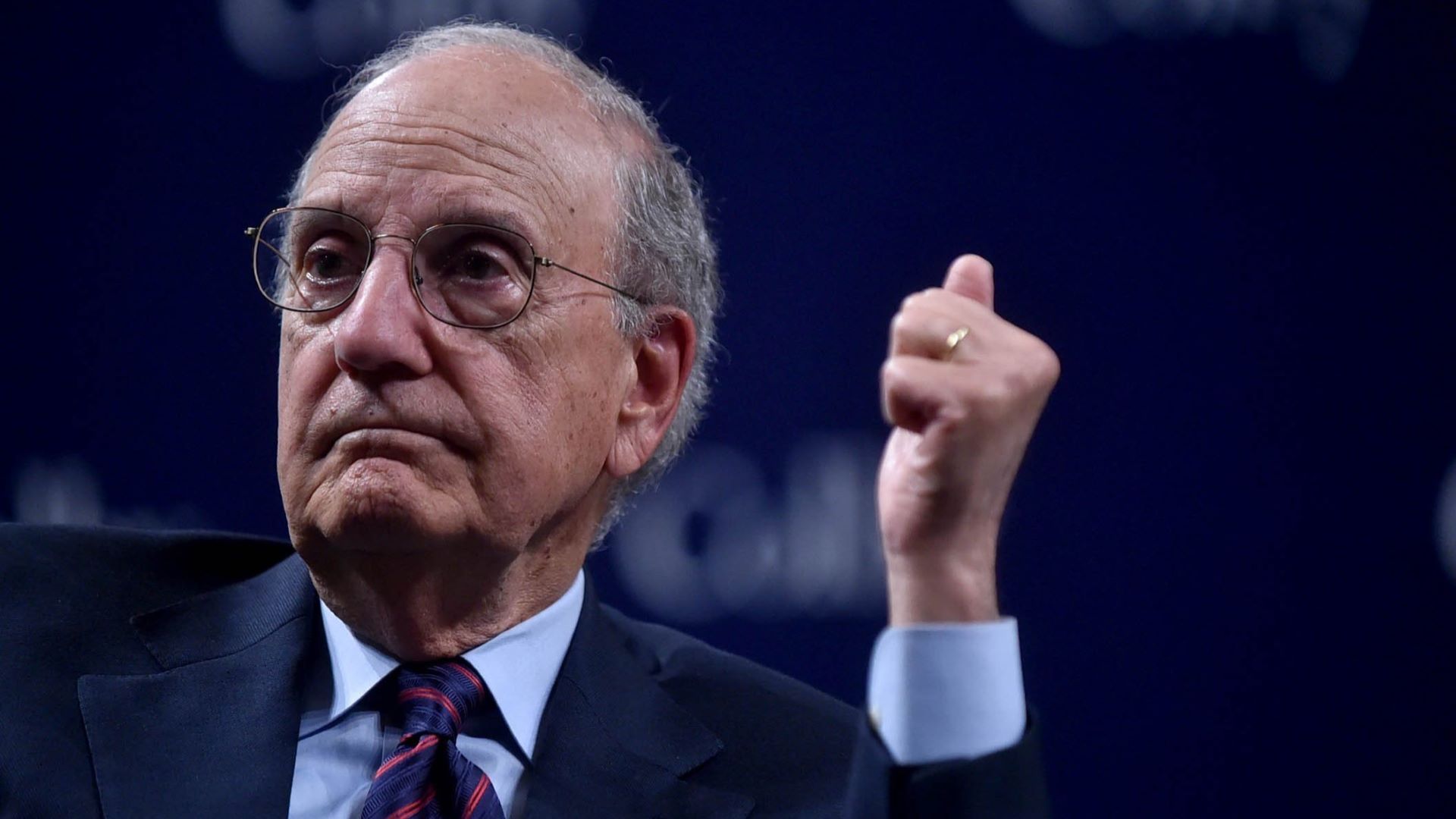 George Mitchell sits and listens to a speaker (not shown) at an event