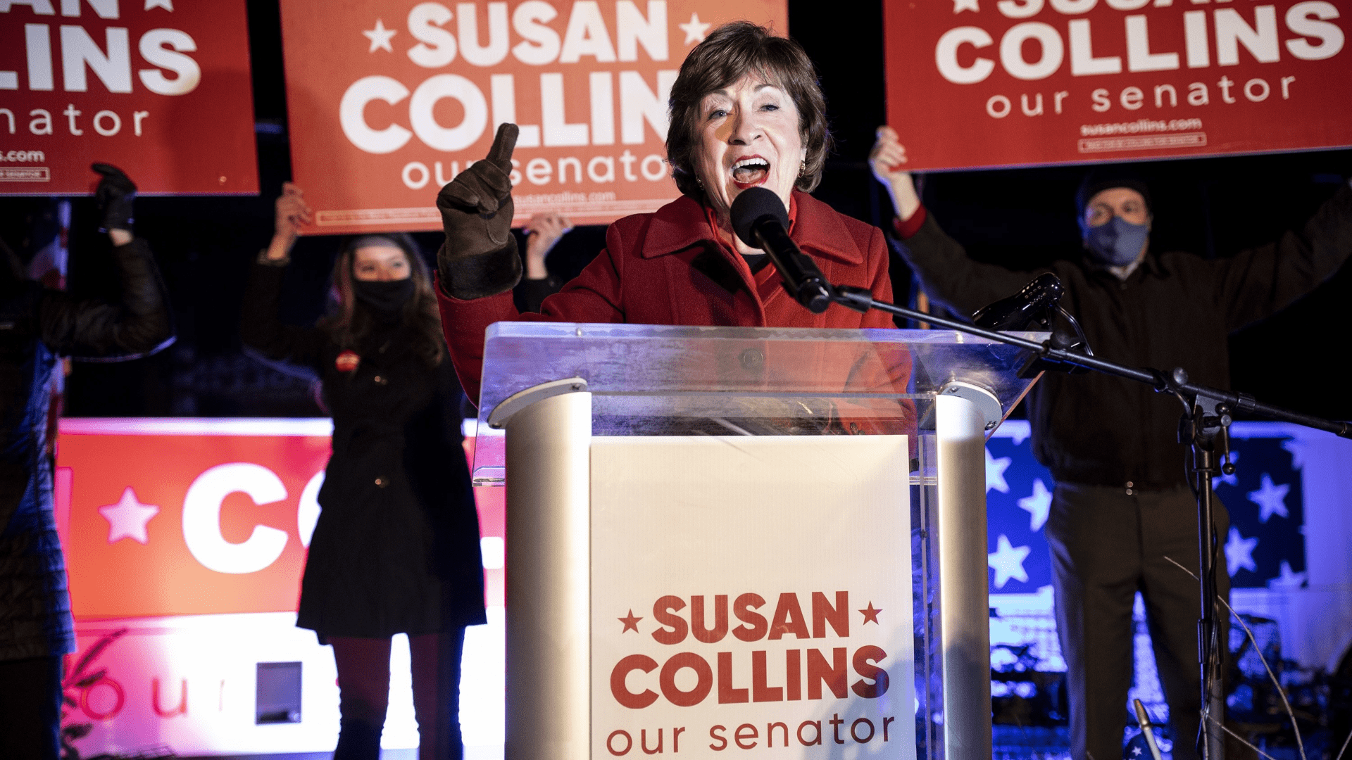Susan Collins speaks into a microphone while standing at a podium during a campaign event