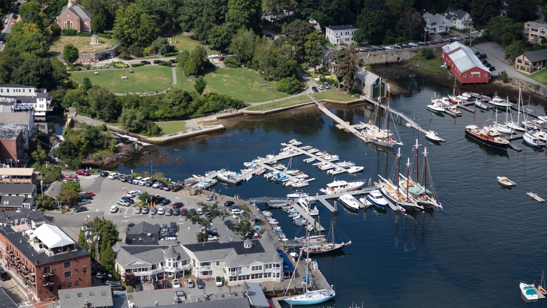 Aerial view of Camden Harbor showing how close a parking lot and public grass area is to the water