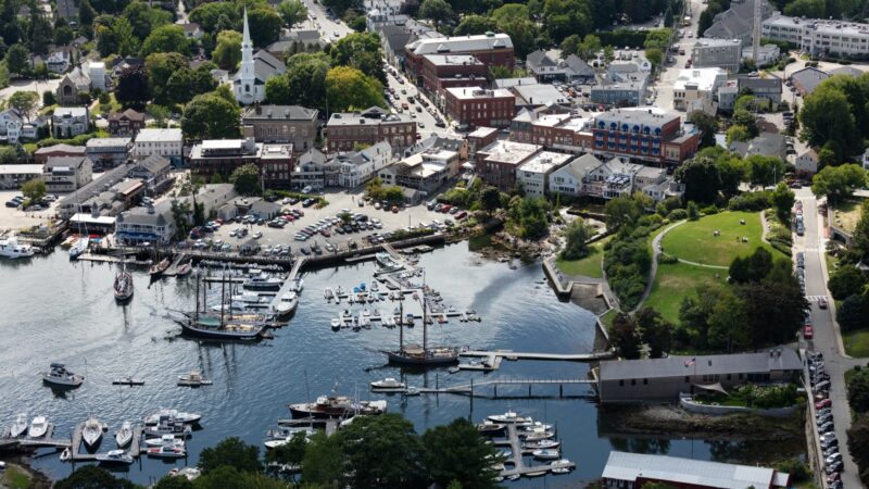 Aerial view of Camden Harbor showing how close a parking lot and public grass area is to the water.