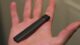 A juul vaping device rests in the palm of an outstretched hand