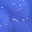 Droplets of rain on a blue rain jacket