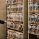 Cumberland County District Attorney Jonathan Sahrbeck sifts through a shelf packed with active case flies at the Cumberland County Courthouse.