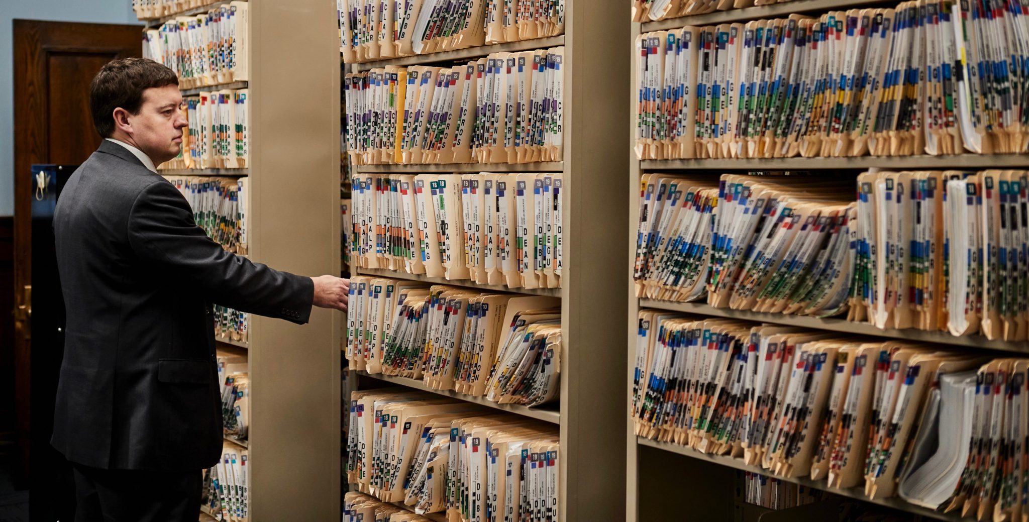 Cumberland County District Attorney Jonathan Sahrbeck sifts through a shelf packed with active case flies at the Cumberland County Courthouse.