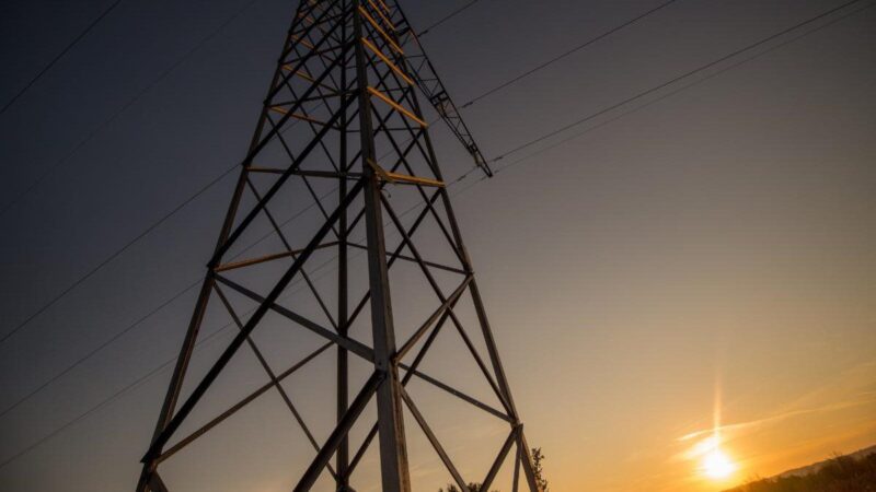 A photo of transmission lines at sunrise