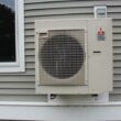 A heat pump attached to the outside of a building