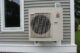 A heat pump attached to the outside of a building