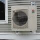 A heat pump attached to the outside of a building