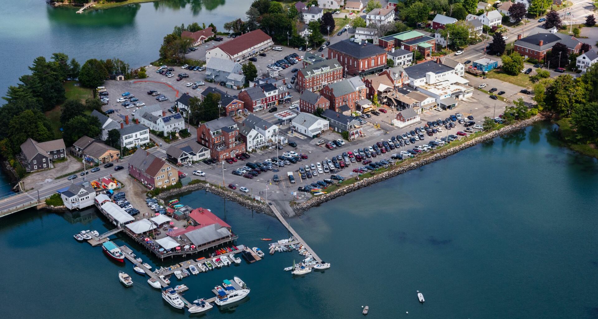 Aerial view of the body of water that surrounds parking lots in Damariscotta
