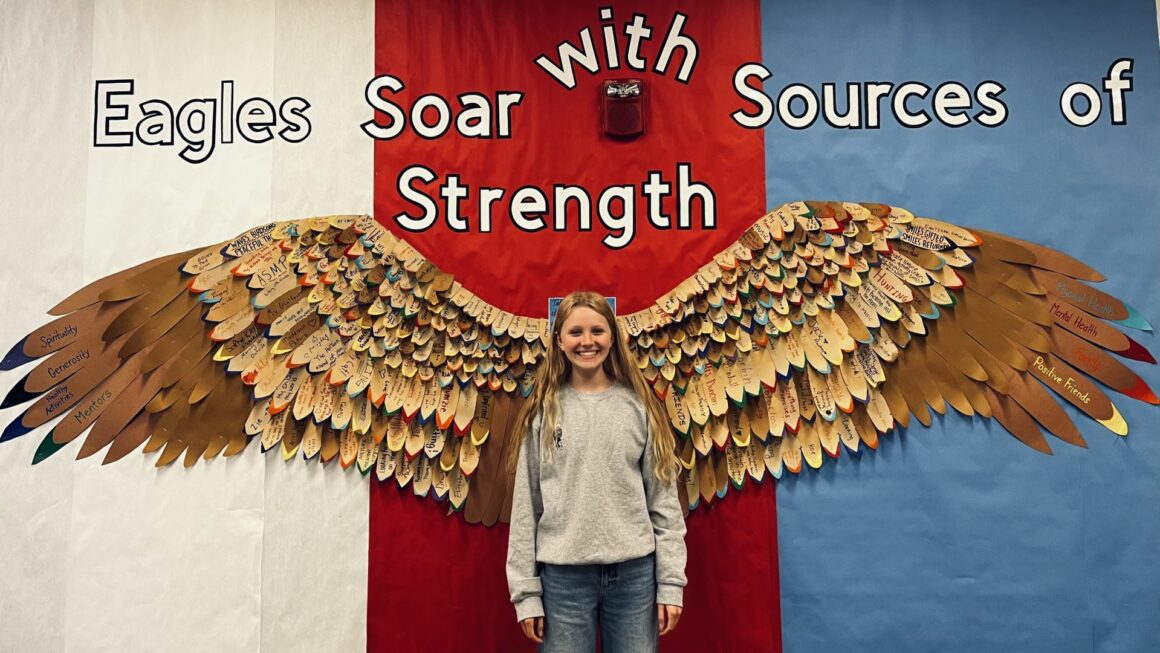 Rose Tuttle stands in front of the Sources of Strength eagle wings