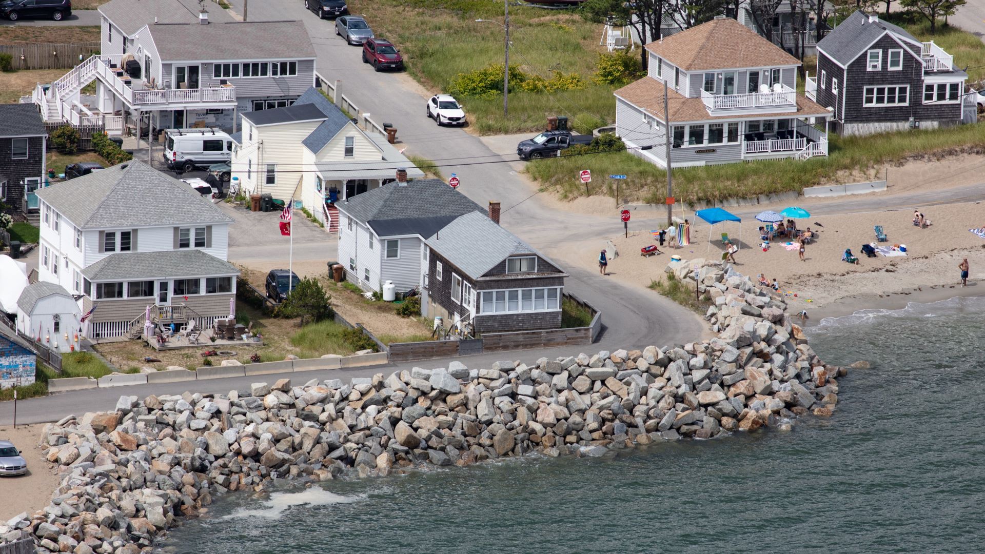 Aerial view of homes that are protected, for now, by a sea wall in Saco. To the right is the start of a beach.