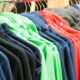 Different colored jackets hang in a closet.