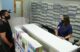 A customer and pharmacist engage in a conversation at a pharmacy counter