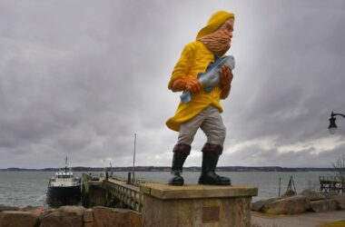 A statue of a fisherman holding a fish by the ferry terminal in Eastport, Maine