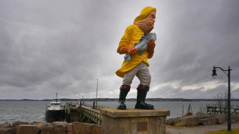 A statue of a fisherman holding a fish by the ferry terminal in Eastport, Maine