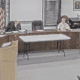 Shastri Ramnath, president of Exiro Mineral Corp, stands at a podium while speaking to a crowd of town residents. Members of the select board are seated behind her.