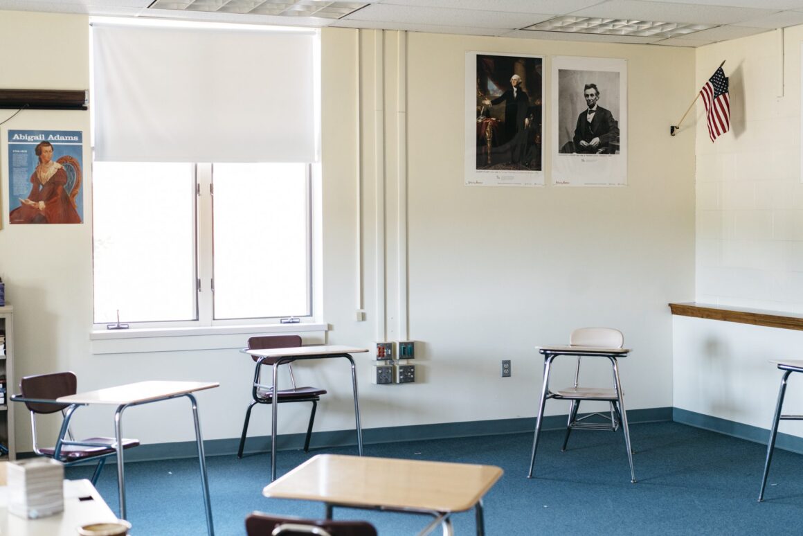 An empty classroom with four desks for students spread out for social distancing amid COVID-19