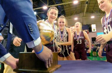 Players from the Ellsworth high school girls basketball team prepare to be handed the gold basketball state championship trophy.