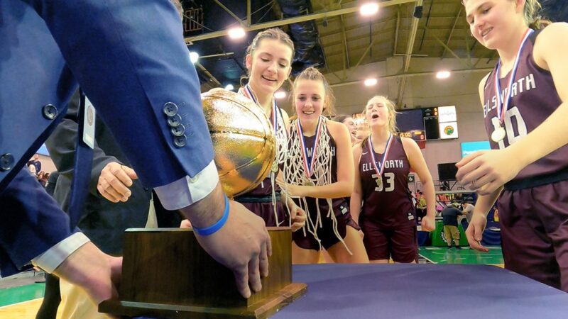 Players from the Ellsworth high school girls basketball team prepare to be handed the gold basketball state championship trophy.