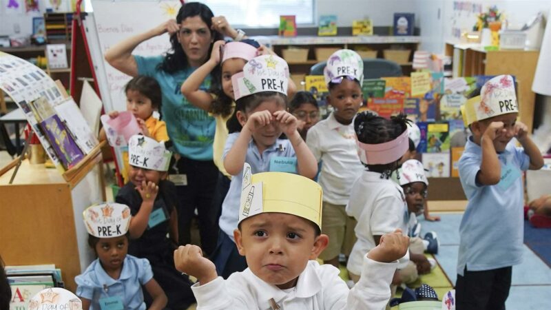 A classroom of Pre-K students dance to a song in a classroom.