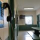 A phone hangs on a wall inside a common area at a jail.