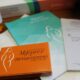 An orange box of the mifepristone abortion pill sits on a table among booklets and a pill bottle.