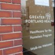 The glass door entrance to the Great Portland Health facility. "Healthcare for the Homeless Program. Walk-ins Welcome."