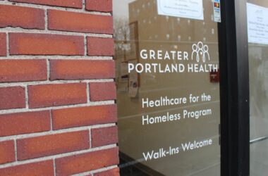 The glass door entrance to the Great Portland Health facility. "Healthcare for the Homeless Program. Walk-ins Welcome."