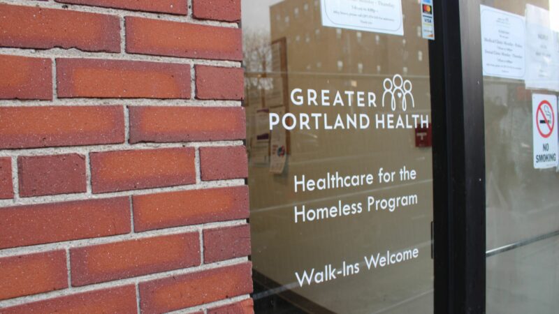 The glass door entrance to the Great Portland Health facility. "Healthcare for the Homeless Program. Walk-ins Welcome."