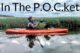 A Black woman paddles while sitting in a kayak on the water. Overlayed text reads "In The Pocket" with periods after the p, o, and c to represent the abbreviation for People of Color.